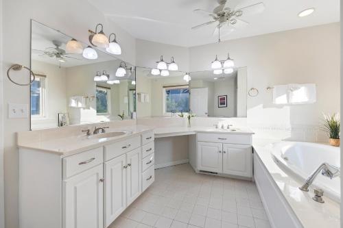 une grande salle de bain blanche avec deux lavabos et une baignoire dans l'établissement MG3080: 3080 Marshgate, à Seabrook Island