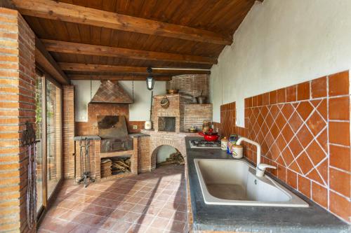 a kitchen with a large sink and a stone oven at Villa Di Mauro in Viagrande