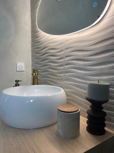 a bathroom with a white sink and a round mirror at La Noccemada, Bastide secrète et Table Gastronomique in Saint-Julien
