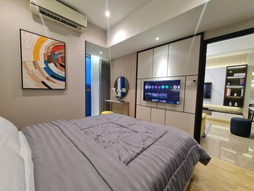 una camera da letto con un letto grande e una TV di Art Inspired Apartment at Branz BSD 1BR a Samporo