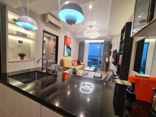 una cucina con lavello e un soggiorno di Art Inspired Apartment at Branz BSD 1BR a Samporo