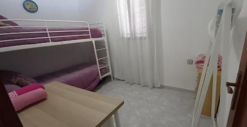 a small room with a bunk bed and a table at Casa Campanilla Valle De Abdalajis in Valle de Abdalagís