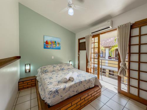 um quarto com uma cama e uma varanda em Lemuria Apart Hotel em Florianópolis