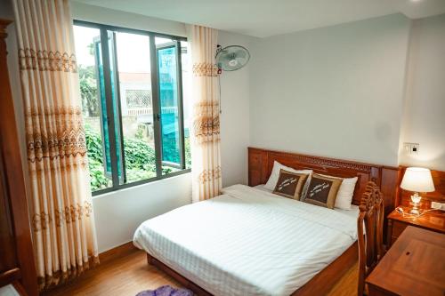 une chambre avec un lit et une grande fenêtre dans l'établissement Hải Đăng Hotel, à Hàm Yên