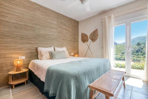 a bedroom with a bed and a large window at Casa Rural La Ruta Naranja in Adsubia