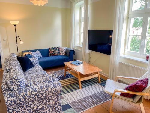 a living room with a blue couch and a table at Eisenbahnerhaus Klausdorf in Klausdorf Mecklenburg Vorpommern