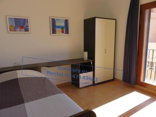 Kasbah del Puerto Rey Apuesto Ático في Playas de Vera: غرفة نوم بها سرير وباب زجاجي منزلق