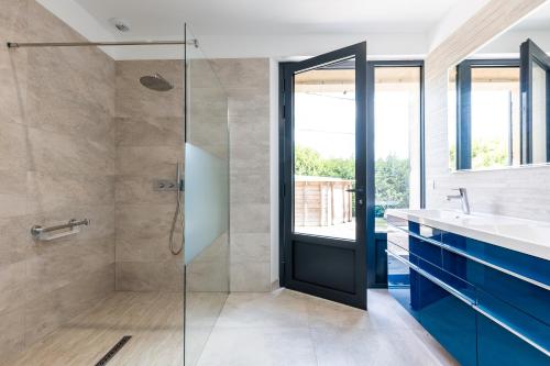 ein Badezimmer mit Dusche und Glastür in der Unterkunft L'Ecrin Du Chateau Canon Montségur in Les Salles-de-Castillon