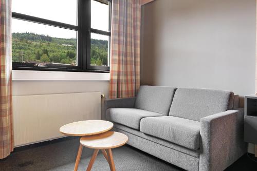 a living room with a couch and a table and a window at Trysil Hotel in Trysil