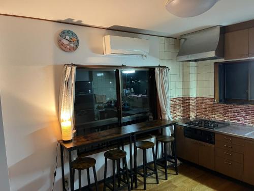 eine Küche mit einer Theke mit Hockern in der Unterkunft Namihaya Inn Hanon - Vacation STAY 69722v in Dejima