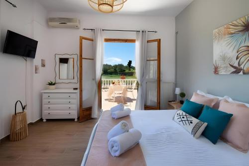 a bedroom with a large white bed with blue pillows at Maestro Apartment 2 in Vlachopoulátika