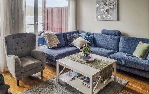 a living room with a blue couch and a chair at Nice Apartment In Korshamn With House Sea View in Korshamn