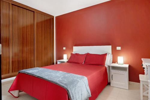a red bed with red pillows in a bedroom at Casa Candido 2 in Playa Honda