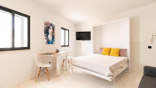 a white bedroom with a bed and a desk at Mi Casa Es Su Casa Nº4 in Albufeira
