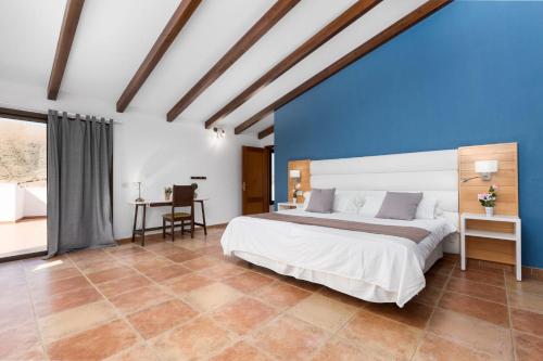 a bedroom with a large bed and a blue wall at Villa Selena in Pájara