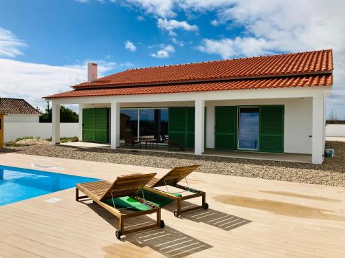 a house with a pool and two chairs next to it at Casa Elo - Fresh-Built Home with Pool in Alcorochel