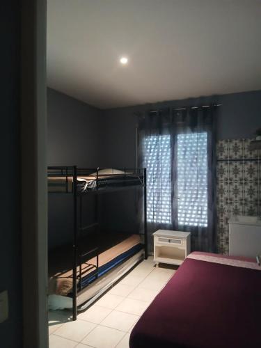 Un dormitorio con dos literas y una ventana. en Étoile de mer, en Vias