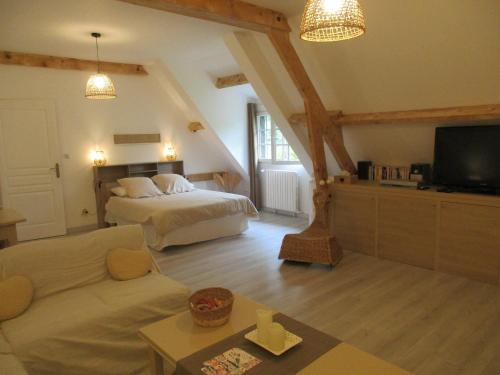 a living room with a bed and a couch at Suite Maraval Chez L'habitant in Trélissac