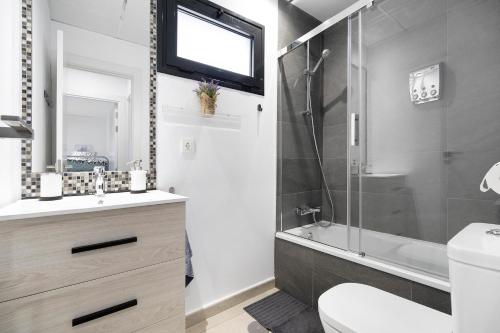 a bathroom with a shower and a toilet and a sink at Apartamento Punta Candor in Rota