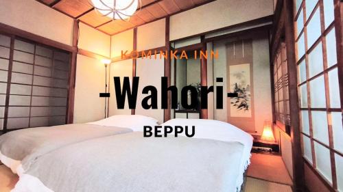 a bedroom with a white bed with a sign that reads walnut gmaxwell at Wahori - A Traditional Japanese Guesthouse in Beppu