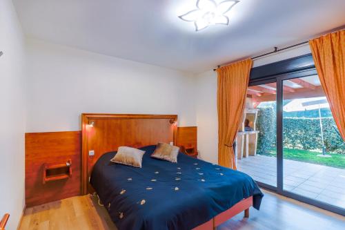 ein Schlafzimmer mit einem Bett und einem großen Fenster in der Unterkunft Maison Hyacinthe in Castelnaud-la-Chapelle