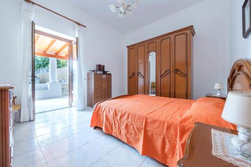 a bedroom with a bed with an orange bedspread at Casa Sole a Canneto in Lipari