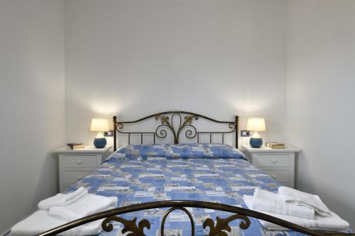 a bedroom with a blue bed with two lamps at Dolcecasa in Dorgali