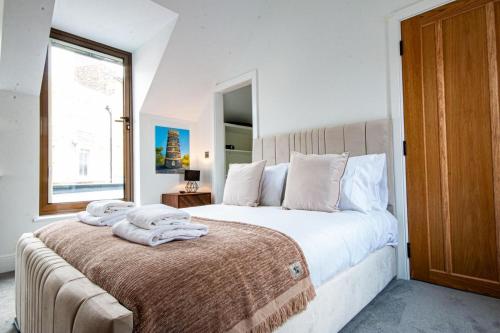 a bedroom with a large bed with towels on it at Escape to Broadstairs in Broadstairs