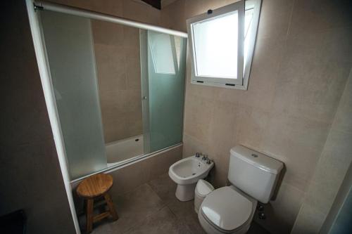 Un baño con inodoro, lavabo y ventana. en Soles de Belén, en Carpintería