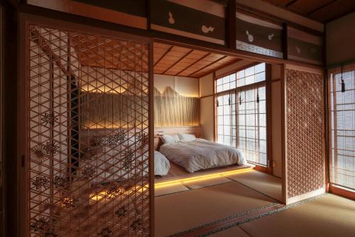 Un dormitorio con una cama en una habitación con ventanas. en Sion Hotel, en Hatsukaichi