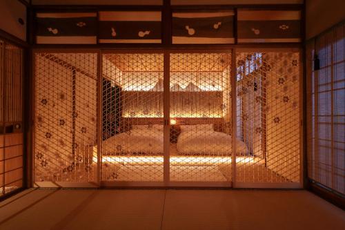 a room with a glass door with a bed inside at Sion Hotel Private Luxury Ryokan with Tea Ceremony in Hatsukaichi
