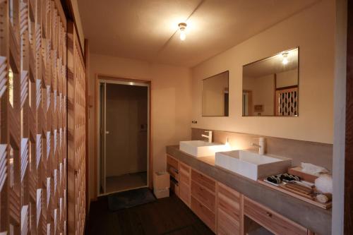 Un baño con dos lavabos y un espejo. en Sion Hotel, en Hatsukaichi