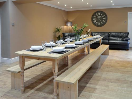 a wooden table with plates and wine glasses on it at Farmhouse in Dunragit