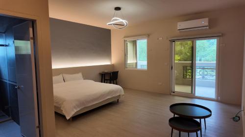 a bedroom with a bed and a table and chairs at 樹海翠湖 in T'ung-ko