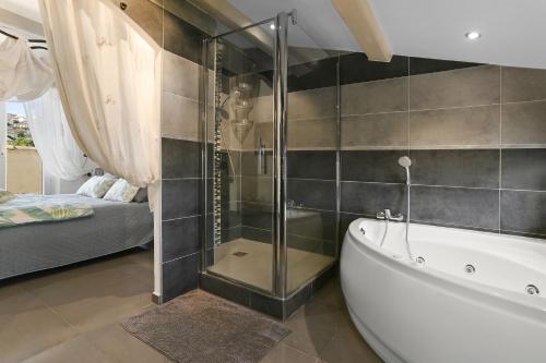 ein Bad mit einer Badewanne und ein Schlafzimmer in der Unterkunft Maison au Soleil d'Azur in Fréjus