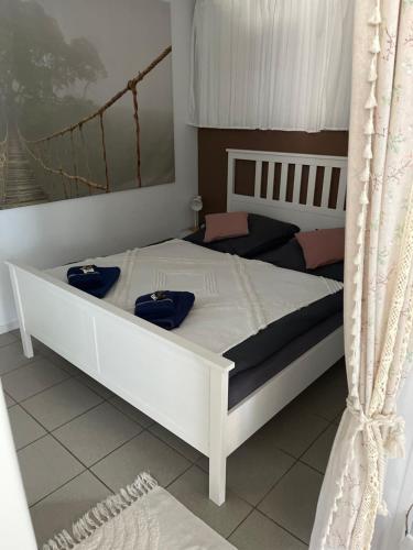 a bedroom with a white bed with blue pillows on it at Trentseeparadies in Plön
