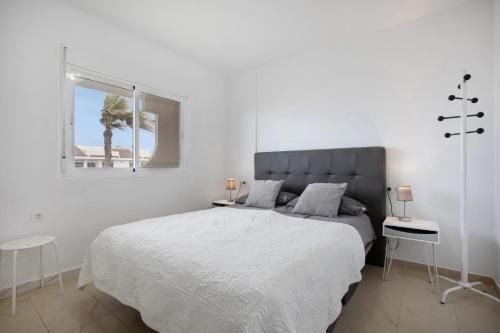 a white bedroom with a large bed and a window at Casa Jable in Costa de Antigua