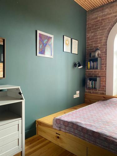 a bedroom with a bed and a blue wall at Train Home #3 in Švenčionėliai