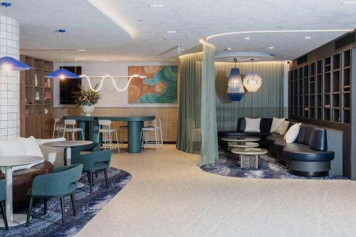 a lobby with a couch and tables and a bar at Bayside Geelong Hotel & Apartments, an Ascend Collection Hotel in Geelong