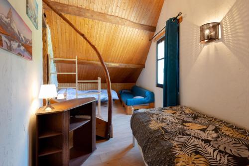 a bedroom with a bed and a desk with a lamp at Gîte de l'éléphant in Murs-et-Gélignieux