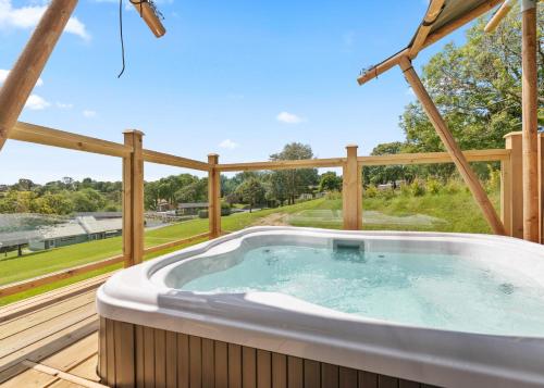 a hot tub on a deck with a fence at Celtic Escapes in Narberth