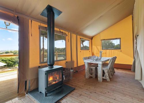 a room with a wood stove and a table at Celtic Escapes in Narberth