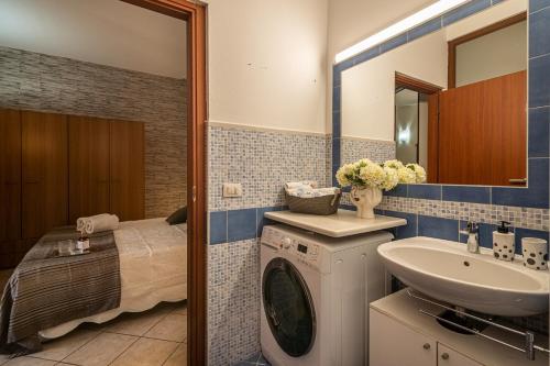 a bathroom with a washing machine and a sink at Casa Niluca in Portoscuso