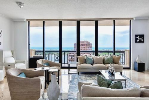 a living room with couches and a view of the ocean at Elegant 2 Bedroom Condo with Ocean Views in West Palm Beach