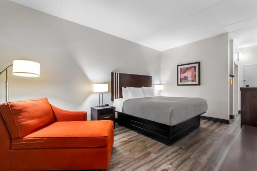 a hotel room with a bed and a chair at Quality Inn Chattanooga Hamilton Place in Chattanooga