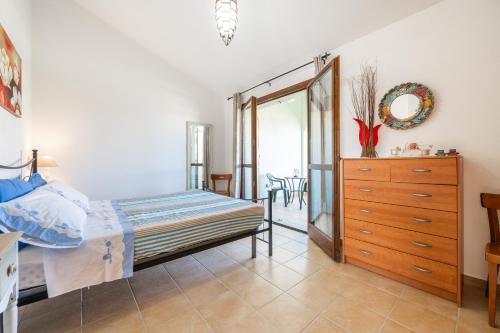 een slaapkamer met een bed, een ladekast en een spiegel bij Casa Roberta in Olìa Speciosa