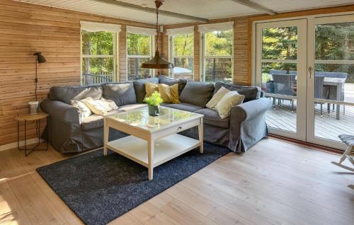 ein Wohnzimmer mit Sofa und Tisch in der Unterkunft Three-Bedroom Holiday Home In Vaggerlose in Bøtø By