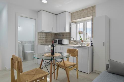 una cocina con una mesa con una botella de vino. en Almazen Alojamiento Rural, en Alcalá de los Gazules