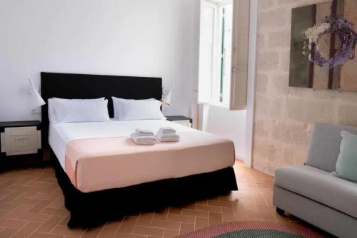 Un dormitorio con una cama grande y un sofá. en Suite 2, en Mahón