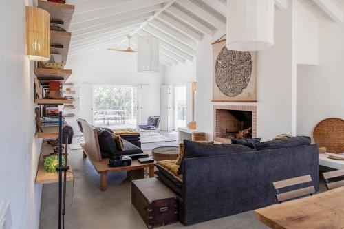 ein Wohnzimmer mit Sofa und Kamin in der Unterkunft Casa Acima in São Bartolomeu da Serra